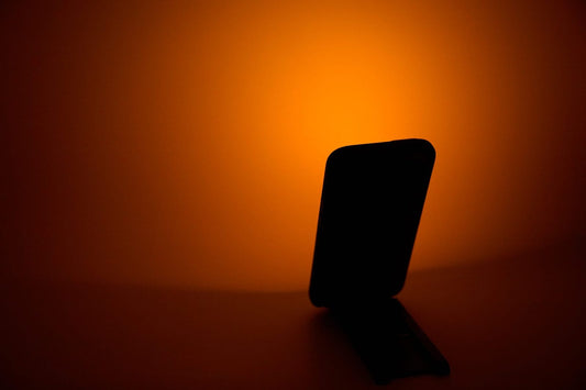 Uses for old phones: phone on a stand with a Solar Orange Flashy casting warm light onto the wall