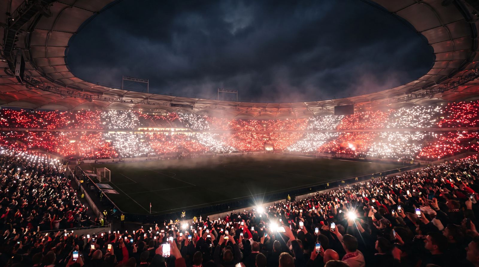 AI-generated visualisation: stadium at night, fans holding up phone lights in red and white
