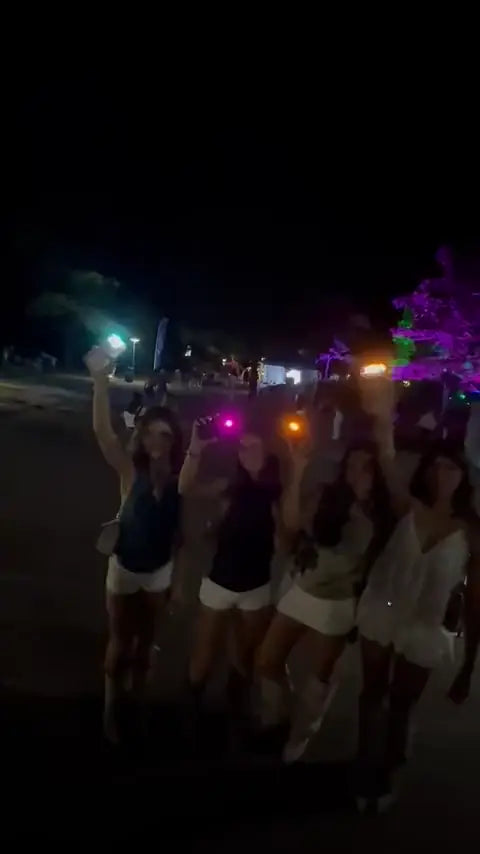 Group on a street at night with pink and orange phone lights