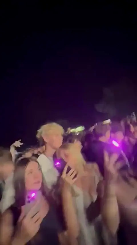 Young people at a party with pink glowing smartphones